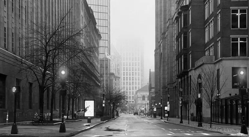 A fog-filled, empty Boston street at night with glowing gas lamps